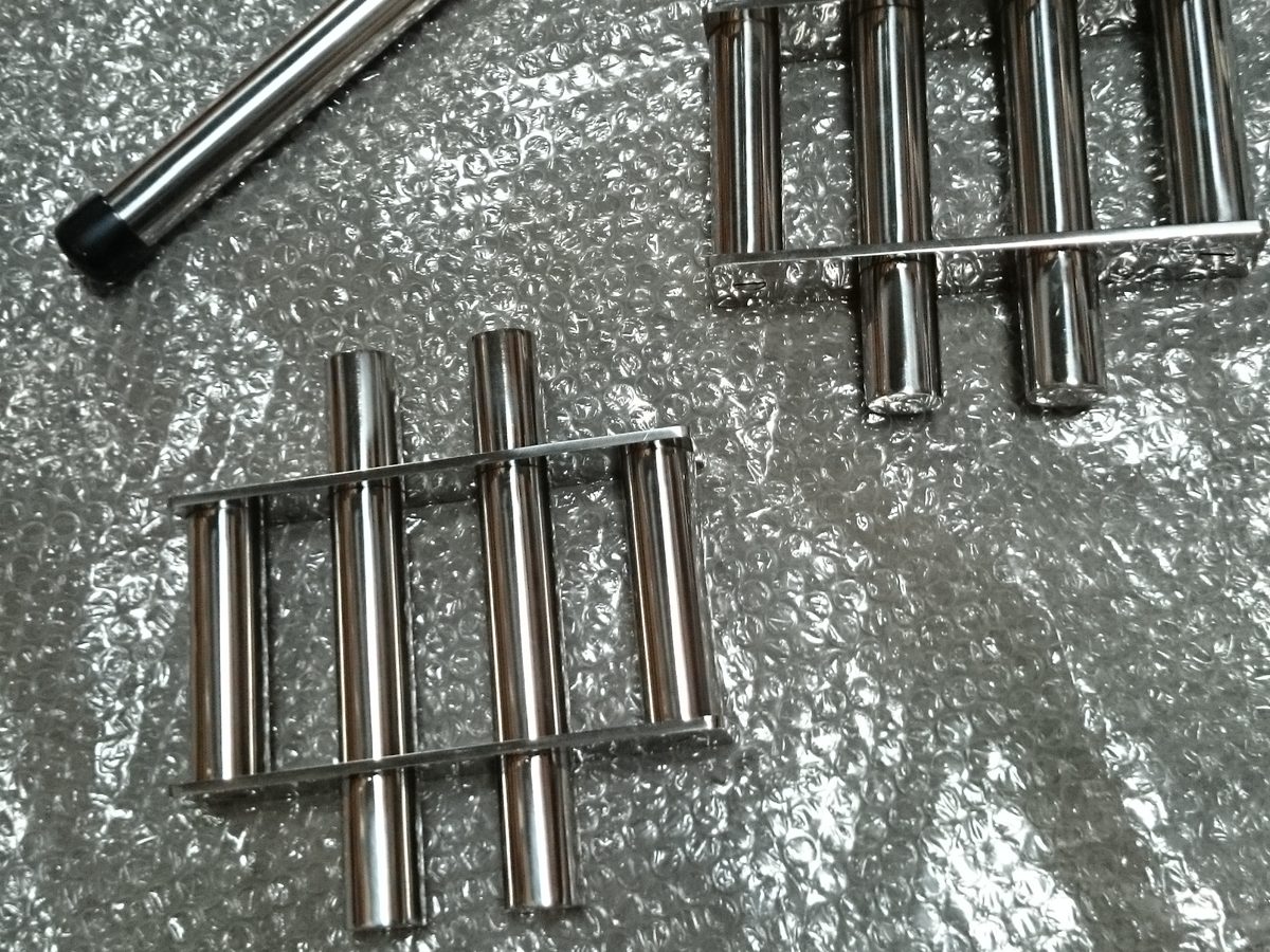 Four-bar stainless steel grate magnet units next to a single magnetic bar