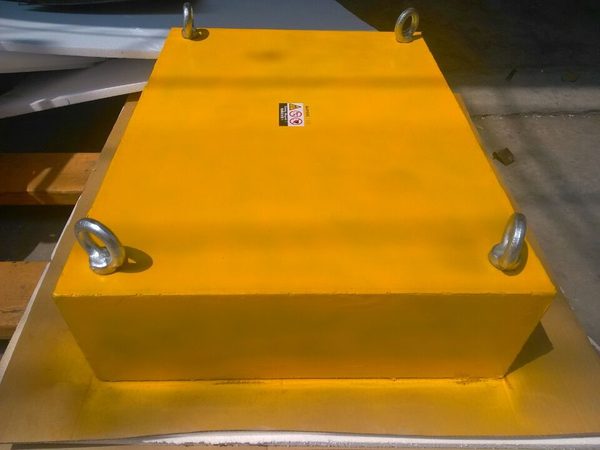 Yellow suspension magnet with four eyebolts for hanging over a conveyor